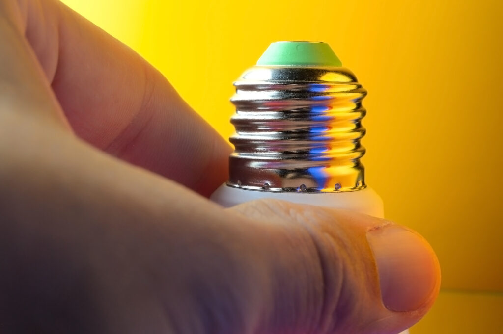 Leuchtmittel E14 mit Edison-Gewinde wird von Hand eingeschraubt